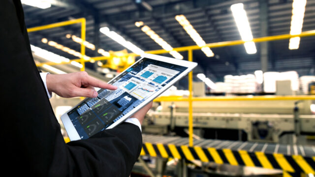 A photograph of a pair of hands holding a tablet with statistics on it.