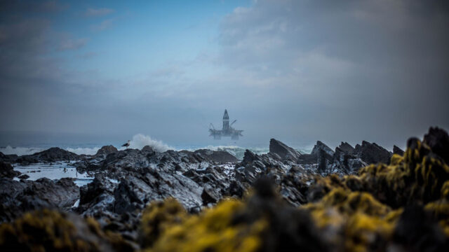 An oil rig from the view of the coastline.